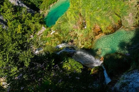 High angle view of a waterfall cascading into a clear turquoise natural poo.. Stock Photos