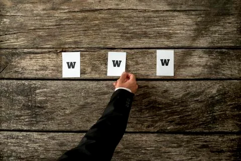 High angle view of web developer placing thre white papers spelling WWW on a  Stockfoto's