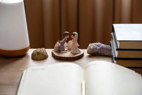 High angle view of wedding couple miniatures and open diary on wooden surface. Stock Photos