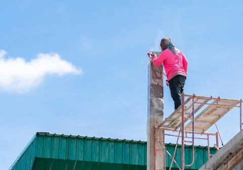 High-angle view of a welder performing structural joint welding on top of a.. Stock Photos