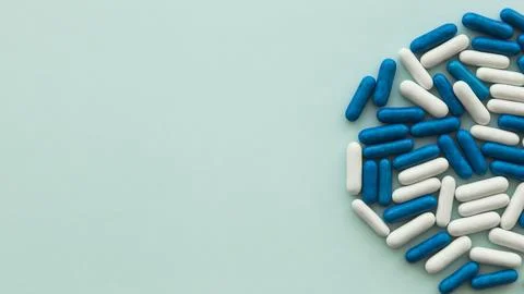 High angle view white blue candy capsules green background. High quality be.. Stock Photos
