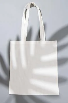 High angle view of white canvas bag with copy space and leaf shadow on grey Stock Photos