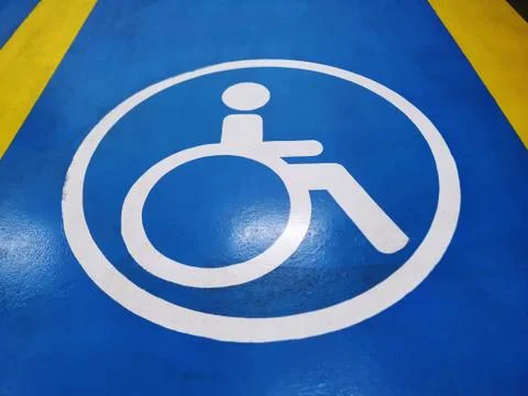 High Angle View of White Handicapped Parking Symbol on Blue Floor Foto stock
