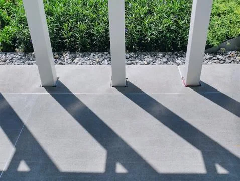 High Angle View of White Pillars with Shadows on Walkway Foto stock