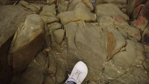 High Angle View Of White Sneaker On Rough Coastal Rocks Stock Footage 310229549