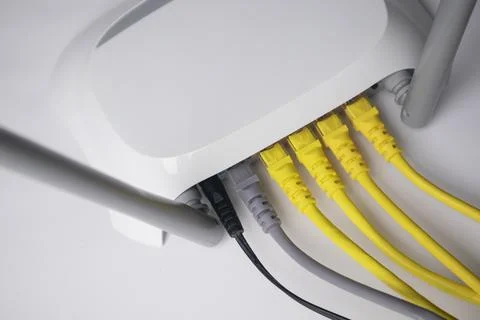 High-angle view of white wireless router back panel with connected yellow a.. Stock Photos
