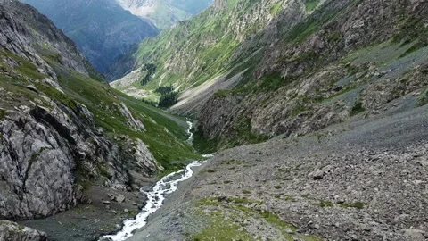 High angle view of winding mountain river in deep rocky gorge with steep slopes Видео 334625154
