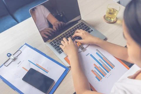 High angle view of woman using laptop and checking sales chart data Fotos de archivo