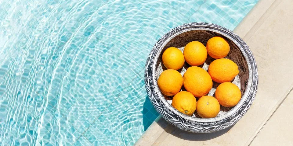High angle view of wooden round tray with oranges floating in swimming pool Stock Photos