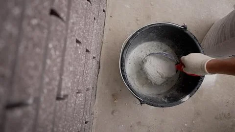 High angle view of a worker mixing cement powder in a bucket. Hand in a glove 스톡 사진