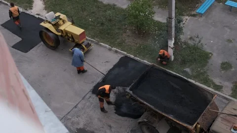 High angle view of workers repairing city road using a yellow roller and fr.. Stock Footage 339802063