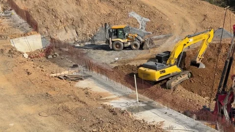 High-angle view of yellow excavator and backhoe loader machines performing Stock Footage 332190766