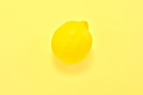 High angle view of a yellow lemon on a yellow background Stock Photos