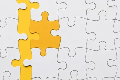 High angle view yellow puzzle piece arranged with white pieces 스톡 사진
