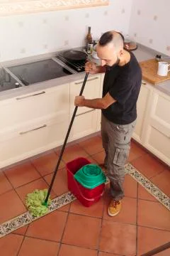 High angle view of a young hispanic self-sufficient man mopping the floor Stock Photos