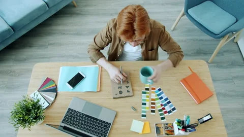 High angle view of young man specialist drawing logo symbols and using laptop Stock Footage 157531046