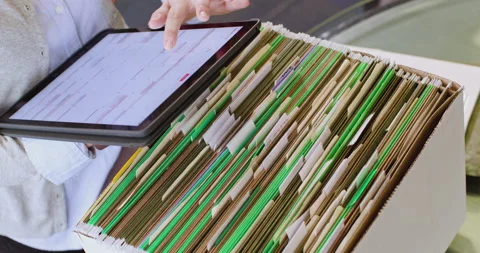 High angle of a woman sorting through files and logging them in a tablet Stock Footage 138664957