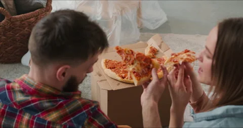 High angle young happy romantic couple sitting on floor relaxing and eating Stock Footage 158081720