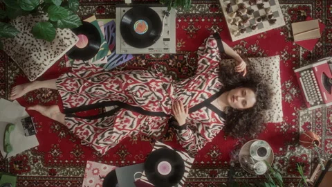 High Angle of Young Woman in Patterned Robe Relaxing on Vintage Rug Stock Footage 339852047