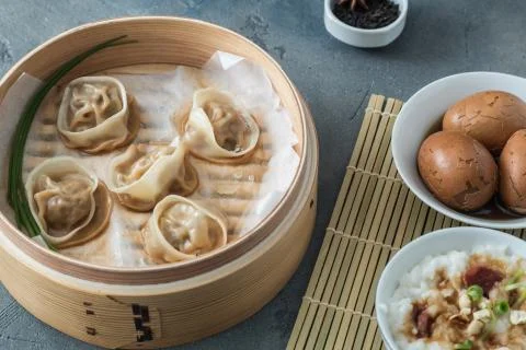 High angled view of cooked dumplings inside bamboo steamer with lip partially Stock Photos