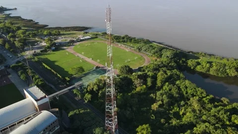 High antenna tower surrounded by trees front to river Vídeo Stock 153645685