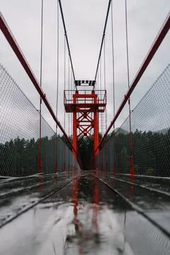 High arched red bridge over the river in the forest. Stock Photos