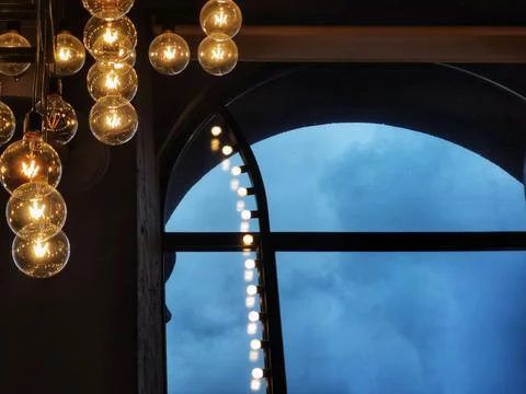 A high arched window in which you can see the sky and lamps - balls Stock Photos