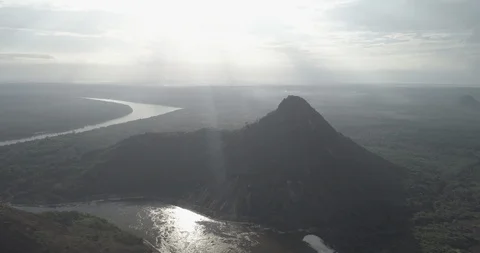 High backlit aerial sails over Inirida river and towards Cerro Mavecure Stock-Footage 100678691
