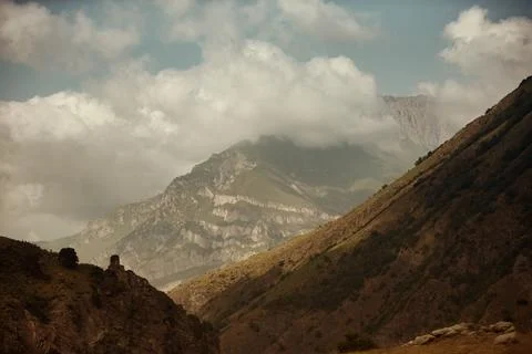 High black rock in low clouds. Surreal gloomy mountains. Foto stock