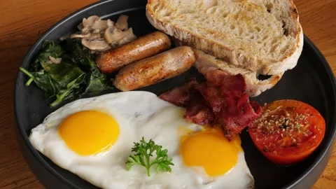 High-calorie breakfast containing fried eggs, turning plate shot Stock Footage 208581025