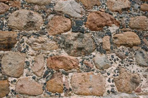 High castle wall made of large stone interspersed with small stones Stock Photos