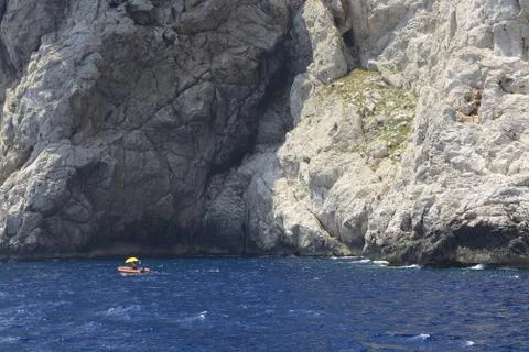 High cliffs and small boat Stock Photos