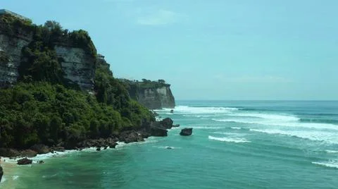 High cliffs standing before the waves of the ocean Stock Photos