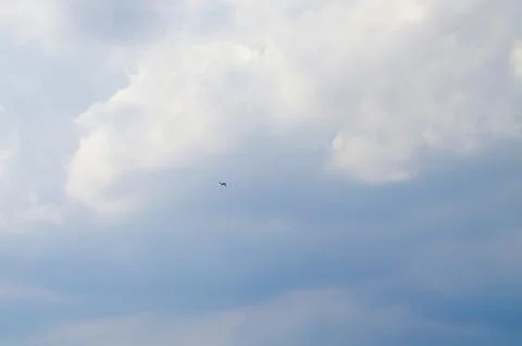 High in the clouds we see a small plane Stock Photos
