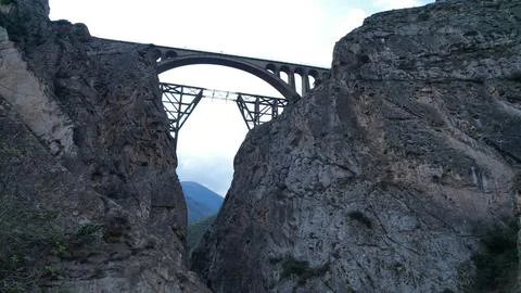 High concrete arch bridge leaps between sheer Iranian cliffs, a mountain Stock Photos