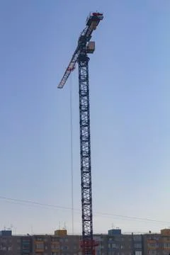 High construction crane against the background of blue sky Stock Photos