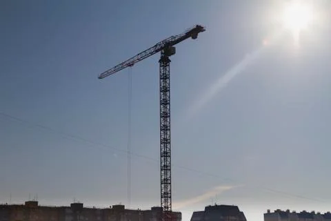 High construction crane against the background of urban development Stock Photos