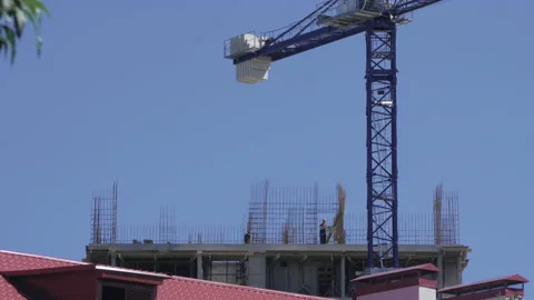 High construction crane. Builders are erecting a new building to build a Stock Footage 142973530