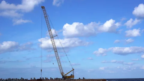 High construction crane next to ocean coast horizon line Stock Footage 137806624