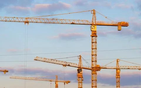 High construction tower crane against the blue sky. Stock Photos
