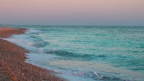 A high definition video of gentle waves crashing on a rocky beach in Oman at sun Stock Footage 318824468