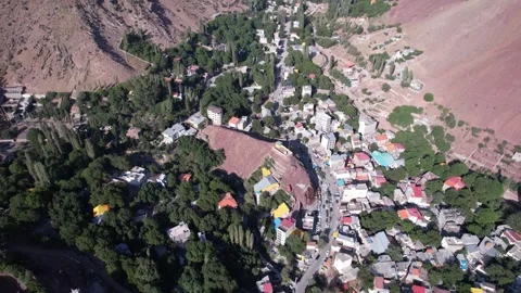 High drone frame of a packed North Road town with many roofs among trees, set Stock Footage 343805989