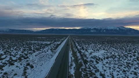 High Drone Shot of Car Driving Towards Snowy Rocky Range - Sangre De Christo Vídeo Stock 324382676