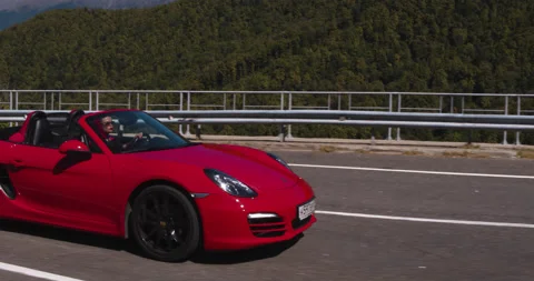 High Drone Shot Red Convertible Traveling on Road Stock Footage 160151091