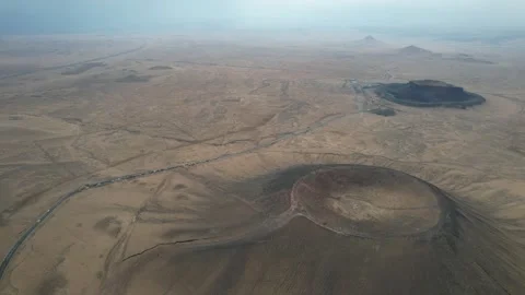 High drone view of volcanic desert cones across arid plain in Xinjiang China Stock Footage 337886787
