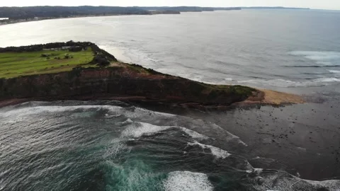 A high drones view of a mountain on the beach flying closer towards the waves Stock Footage 135630719