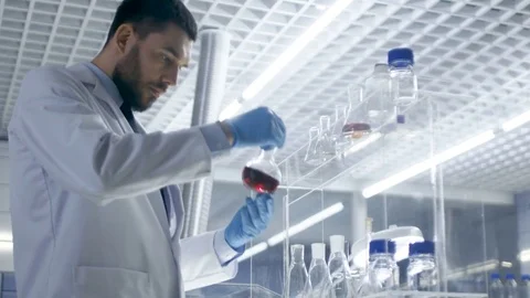 In High-End Laboratory Research Scientist Picks up Beaker of the Shelf Stock Footage 75440867