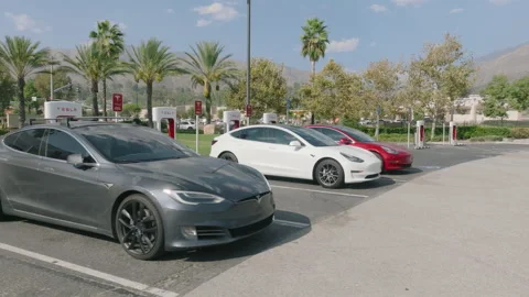 High end red, white and grey EV cars charging at Supercharger station Stock-Footage 233453159