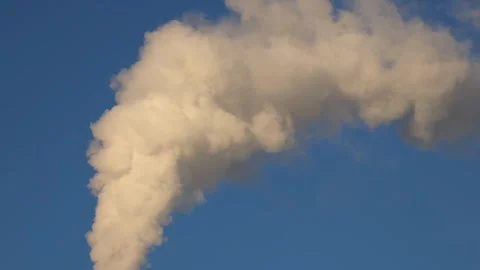 A high factory chimney ejecting smoke at a rapid pace. Slow-motion close-up.. Video stock 297178448