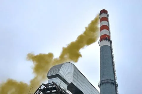 High factory chimney emits dense puffs of toxic green smoke into the environm Stock Photos